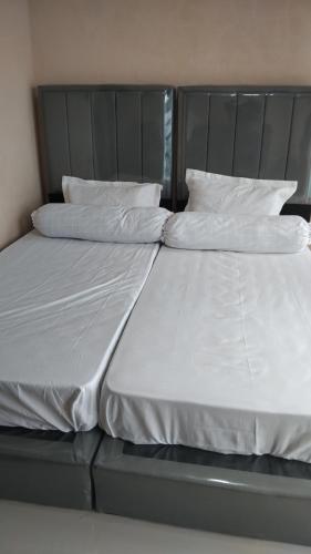 a bed with white sheets and pillows on it at Diara Bungalow in Iboih