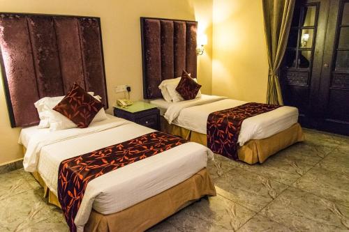 a hotel room with two beds in a room at Beringgis Beach Resort & Spa in Papar