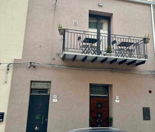 a building with a balcony with a table and chairs at L'Oasi del Tirreno in Lascari