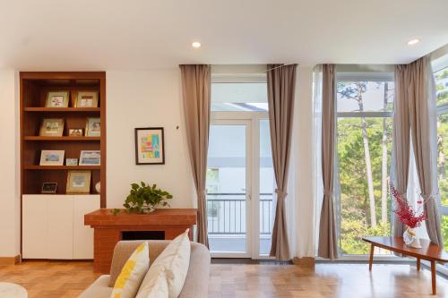 a living room with a couch and a large window at The Dream Villa Best Lake View in Xuan An