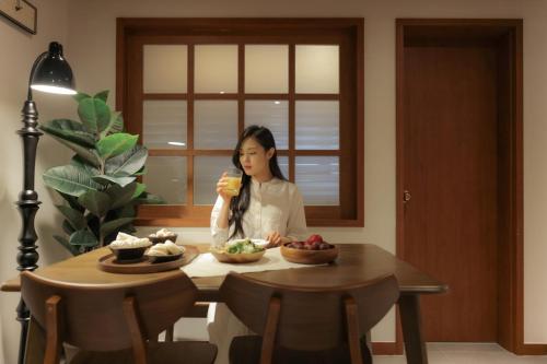 a woman sitting at a table eating a sandwich at Surim Hotel Sokcho by AanK in Sokcho
