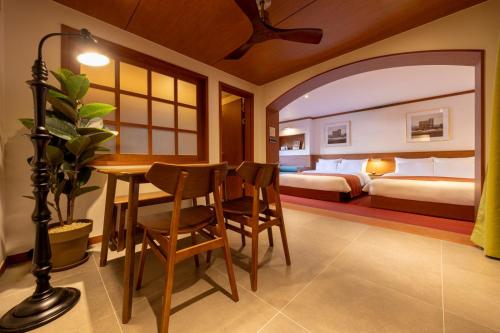 a bedroom with a table and a bedroom with two beds at Surim Hotel Sokcho by AanK in Sokcho