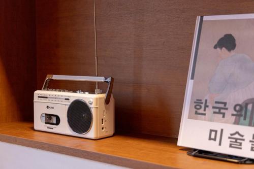 a small radio sitting on a shelf next to a sign at Surim Hotel Sokcho by AanK in Sokcho
