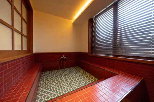 a jacuzzi tub in a room with a window at Surim Hotel Sokcho by AanK in Sokcho