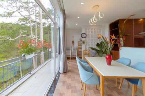 a dining room with a table and chairs and a balcony at The Dream Villa Best Lake View in Xuan An