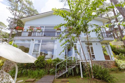 a white house with a balcony and a tree at The Dream Villa Best Lake View in Xuan An