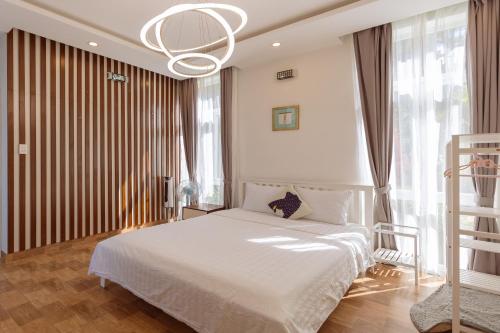 a bedroom with a white bed and a chandelier at The Dream Villa Best Lake View in Xuan An