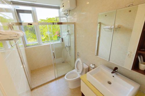 a bathroom with a shower and a toilet and a sink at The Dream Villa Best Lake View in Xuan An