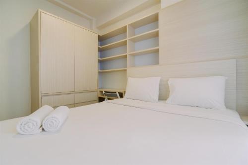 a bedroom with a white bed with two pillows at Warm and Well Designed 2BR Tokyo Riverside PIK 2 Apartment By Travelio in Rawalembang