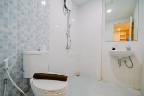 a bathroom with a toilet and a sink at Warm and Well Designed 2BR Tokyo Riverside PIK 2 Apartment By Travelio in Rawalembang