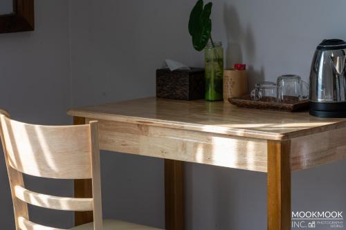 a wooden table with a wooden chair next to a desk at Coconut Lodge in Kampot