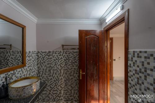 a bathroom with a wooden door and a tub at Coconut Lodge in Kampot
