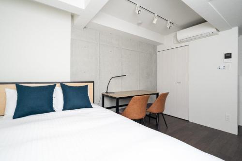 a bedroom with a bed and a table and chairs at LEGA LAND Hatagaya in Tokyo