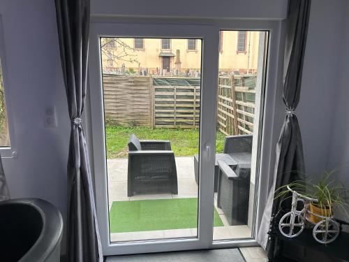 une porte coulissante en verre menant à une terrasse avec une chaise. dans l'établissement Willa willi, à Niederschaeffolsheim