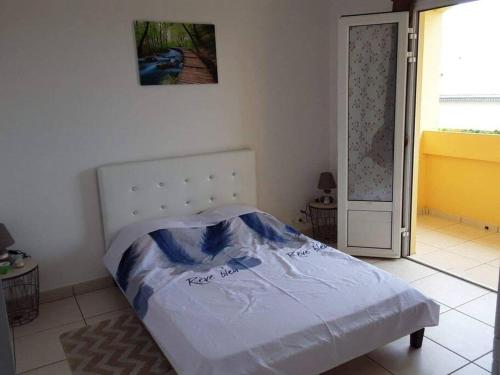 une chambre avec un lit dans une pièce avec une fenêtre dans l'établissement Entre mer et montagne, à Le Tampon