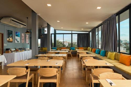 a restaurant with wooden tables and chairs and windows at Red Door Samsen Hotel, Bangkok in Bangkok