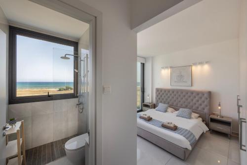 a bedroom with a bed and a view of the ocean at Villa Pliades in Ayia Napa