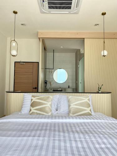 a bedroom with a large bed with two pillows at The Present Samed pool villa in Ko Samed