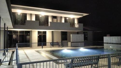 a building with a large swimming pool at night at DLAYARAN HOTEL & CAFE in Kuala Rompin
