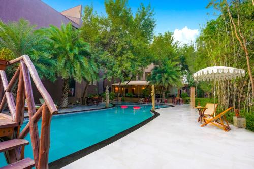 a swimming pool in a yard with palm trees at The Tree House Resort, A Club Mahindra Associate in Jaipur