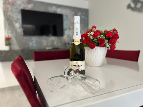 a bottle of wine and a pair of glasses on a table at 2020 House in Manfredonia