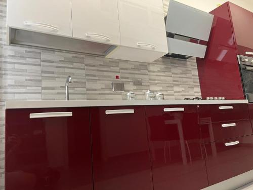 a kitchen with red cabinets and a sink at 2020 House in Manfredonia
