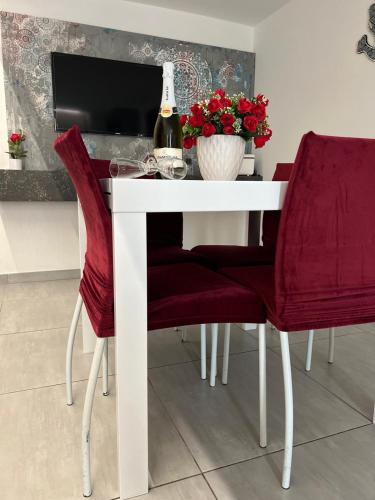 a white table with red chairs and a bottle of wine at 2020 House in Manfredonia