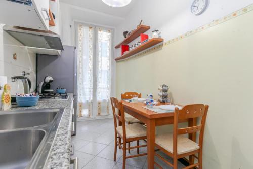 Una cocina con una mesa y sillas de madera junto a un fregadero. en "Cà Niella" Art and Fun 9 Minutes from the Sea, en Savona