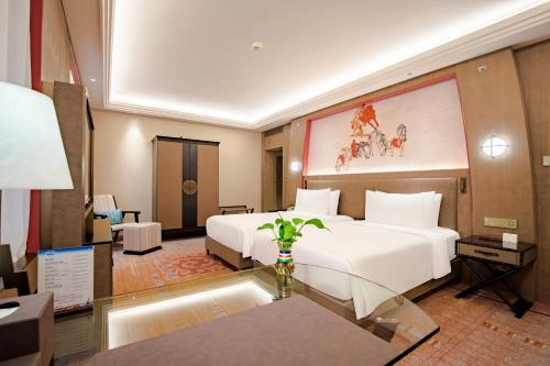 a hotel room with a large white bed and a table at Chengdu Tibetan Hotel-Free Welcome Tibetan Tea in Chengdu