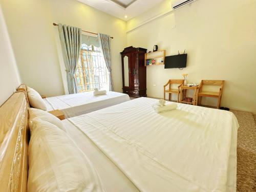 a hotel room with two beds and a television at Khách Sạn Tiến Loan in Hòa Bình
