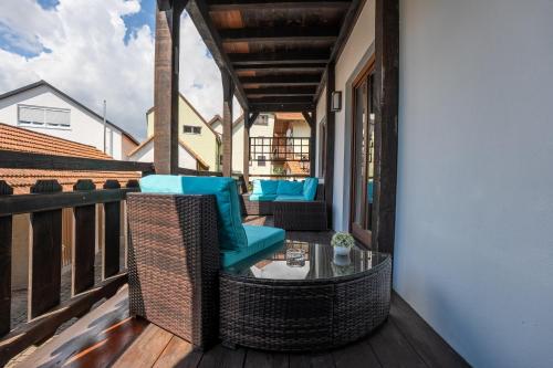 a balcony with wicker chairs and a glass table at Fachwerk Design-Apartment Sinsheim in Sinsheim