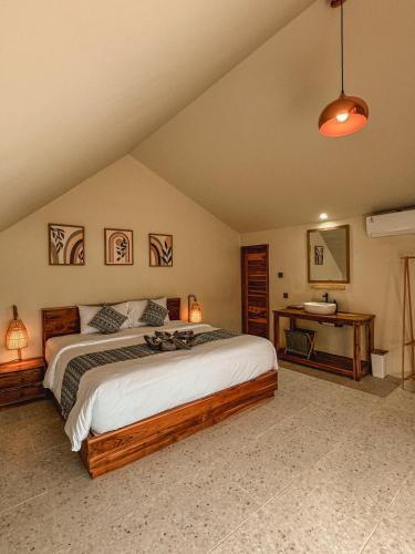a bedroom with a large bed and a desk at Aloka Penida in Klungkung