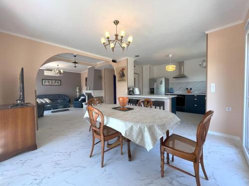 une cuisine et une salle à manger avec une table et des chaises dans l'établissement Appartement dans maison au 1er étage avec terrasse jardin ombrage et parking securise, à Béziers