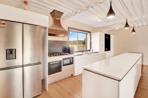 a kitchen with stainless steel appliances and white cabinets at Containers on Kidston in Mansfield