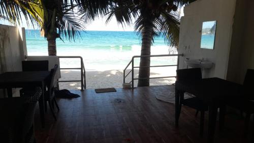 a room with a view of the beach with palm trees at Blue Ocean Hotel in Trincomalee