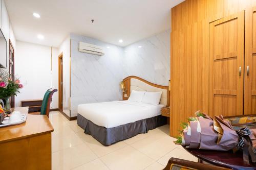 a hotel room with a bed and a desk at Lam Kinh Hotel in Ho Chi Minh City