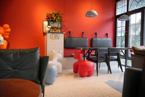 a dining room with red walls and a table and chairs at 不负韶华青年旅馆 Youth Hostel in Suzhou