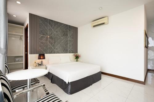 a hotel room with a bed and a table and a table and chairs at Lam Kinh Hotel in Ho Chi Minh City