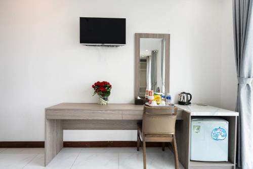 a desk with a mirror and a television on a wall at Lam Kinh Hotel in Ho Chi Minh City