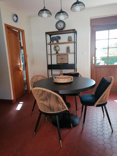une salle à manger avec une table et des chaises noires dans l'établissement Auberge a la Ferme, à Surques