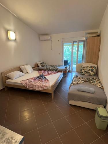 a room with two beds and a couch in it at SNG Apartmani in Brca