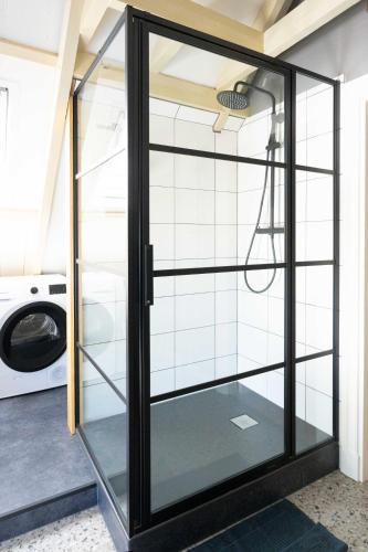 a glass door in a laundry room with a washing machine at Sfeervol verblijf in oude gemeentehuis Eenrum. in Eenrum