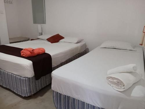 deux lits côte à côte dans une pièce dans l'établissement Aligama Cottage, à Talakolawela
