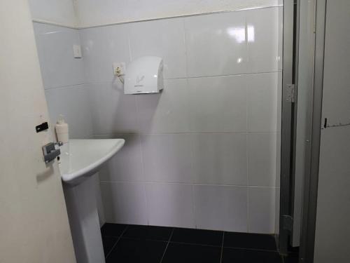 une salle de bain blanche avec lavabo et douche dans l'établissement Aligama Cottage, à Talakolawela