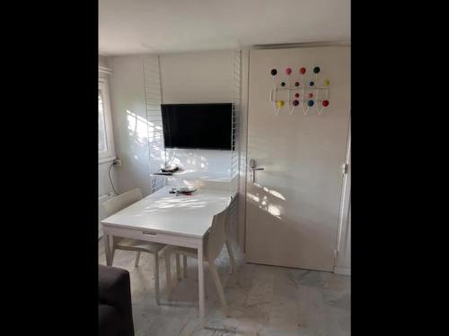 un bureau blanc dans une pièce avec une télévision au mur dans l'établissement Nice cosy studio, à Nice