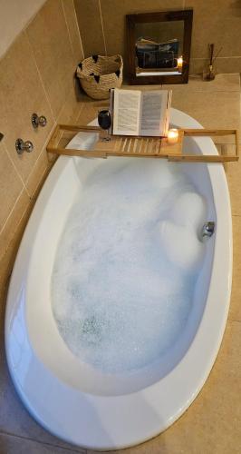 a bath tub with a book on top of it at Grobler's Haven in Pretoria