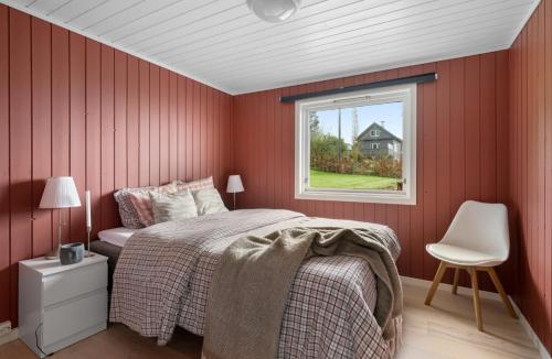 una camera da letto rossa con un letto e una finestra di The Green Bay a Sandnes