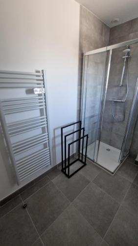 La salle de bains est pourvue d'une douche et de carrelage. dans l'établissement Appartement DMV, à Longaulnay