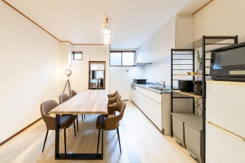 a kitchen and dining room with a wooden table and chairs at Grandest living Nipponbashi 2Bedroom in Osaka