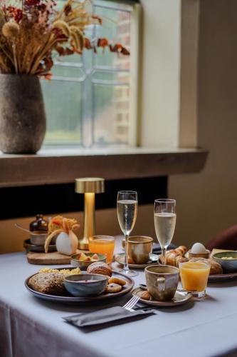 a table with plates of food and glasses of wine at Priorij Corsendonk in Oud-Turnhout